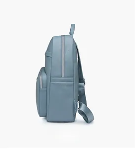 Side view of light blue pebbled leather backpack with silver zippers and side pocket