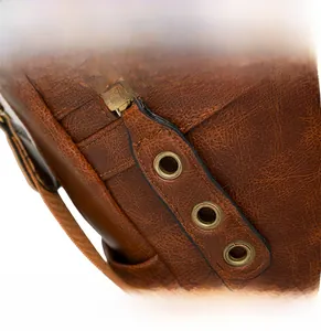 Close-up of vintage brown leather bag detail with decorative zipper and metal eyelets