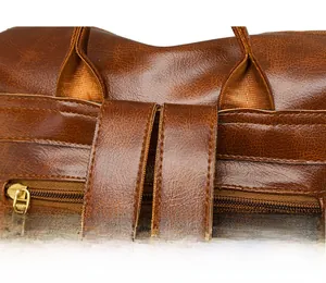 Macro shot of reinforced stitching and matte gold zipper on brown faux leather backpack