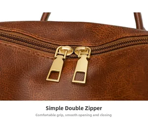 Close-up of golden double zippers on brown textured leather bag with smooth closure