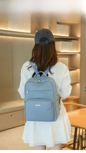 Detailed view of light blue leather backpack with textured finish and metal zipper detail