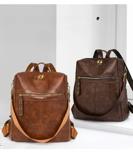 Close-up of brown PU leather backpacks featuring dual zippers and metal eyelet details