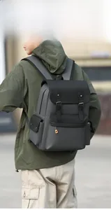 Rear view of a man wearing a vintage gray and black contrast travel backpack outdoors