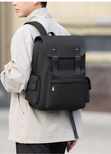 Outdoor detail of black vintage backpack with flip-top buckle and orange zipper accents