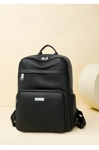Close-up of black lychee grain leather backpack with silver metal zippers and pocket details