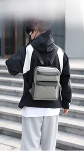 Outdoor shot of a grey color-block lightweight backpack featuring multiple front zipper pockets
