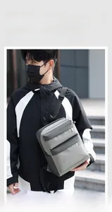 Detail of a lightweight grey travel backpack with multiple pockets on urban stairs