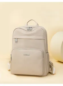 Close-up of beige lychee grain leather backpack with silver zippers and front pocket