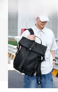 Detail of black tactical backpack with roll-top closure and buckle on a male model