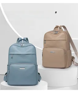 Detailed view of light blue and khaki textured leather backpacks on white displays
