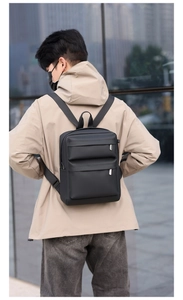Rear view of a minimalist black water-resistant backpack for urban commuting