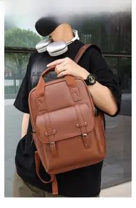 Close-up of brown vintage leather backpack with buckle straps and textured finish