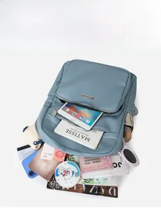 Vue à plat d'un sac à dos en cuir bleu Morandi montrant sa grande capacité pour tablette