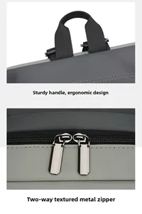 Detail of ergonomic black top handle and smooth metal zippers on grey nylon backpack