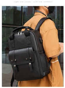 Detail of black leather backpack with side USB charging port and metal buckle design