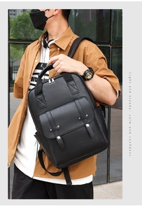 Close-up of black leather backpack with dual decorative straps and silver metal buckles