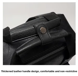 Detail of black leather backpack with reinforced handle, metal snap and litchi texture