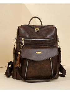 Detail of vintage brown PU leather backpack showing lychee texture and gold metal hardware