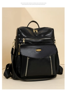 Detail of black faux leather backpack featuring golden metal buckle and tassel decoration