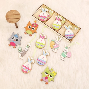 Easter painted wooden bunny and owl hanging ornaments set on white faux fur rug