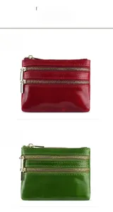 Macro shot of red and green oil wax leather wallets with dual metal zipper compartments