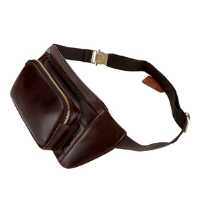 Detail der braunen Vintage-Leder-Gürteltasche mit Messingreißverschlüssen und Gurt