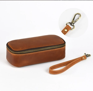 Detail of vintage brown leather pipe pouch with bronze zipper and detachable wrist strap