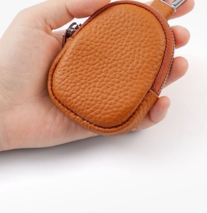 Detailed view of brown litchi grain leather mini pouch with metal hook and zip closure