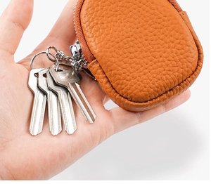 Detail of caramel lychee grain leather key pouch with silver keyring and metal zipper