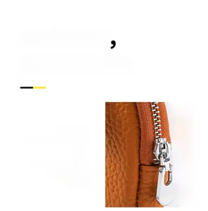 Detail of premium lychee grain leather mini coin purse with smooth metal zipper close-up