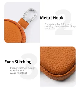 Detail of orange pebble grain leather pouch with silver metal clasp and neat stitching