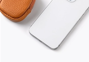 Detailed close-up of orange litchi grain leather mini pouch with silver zipper and phone