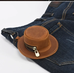 Brown horse leather hat-shaped coin purse hanging from a denim pocket with metal hook