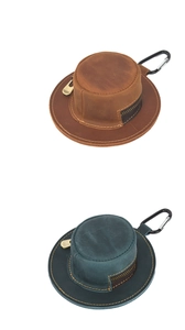 Detail of vintage hat-shaped leather coin pouches in brown and green with metal hooks