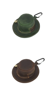 Detail of mini hat coin purses in dark green and brown leather with metal carabiner