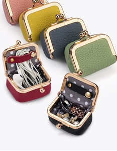 Détail de mini bourses en cuir grainé avec fermoir clic-clac et doublure à pois chic