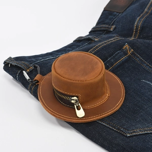 Vintage brown leather hat-shaped coin purse with metal carabiner on denim fabric