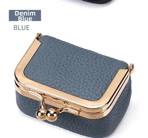 Détail du porte-monnaie en cuir bleu denim avec fermoir métallique doré brillant