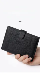 Close-up of black litchi grain leather passport wallet with secure snap closure button