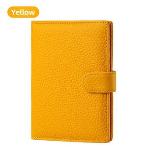 Detail of yellow lychee grain leather passport holder with secure snap button closure