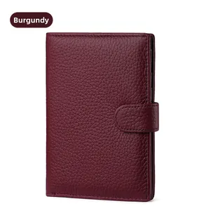 Detailed macro view of wine red leather passport holder with lychee pattern and snap closure