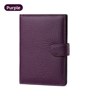 Detail of purple pebbled leather passport wallet with secure snap fastener closure