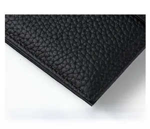 Macro detail of high-quality black pebble leather wallet showing precise uniform stitching