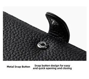 Macro shot of silver metal snap button closure on black pebble grain leather wallet