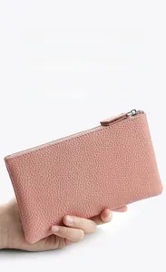 Pink lychee texture leather wallet with silver metal zipper shown in hand close-up