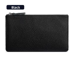 Detail of black pebble grain leather texture and metal zipper on the minimalist clutch bag