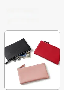 Close-up of three textured leather wallets in black, red, and pink with metal zippers