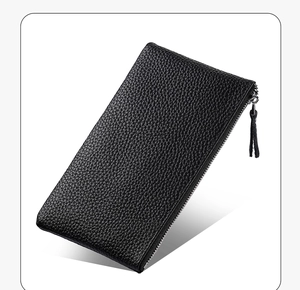 Detailed macro view of black lychee grain leather wallet with a tassel zipper pull