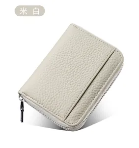 Dettaglio portamonete in pelle crema con slot per carte RFID e chiusura a zip in metallo