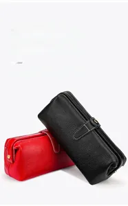 Detail of red and black lychee grain leather makeup bags with gold metal clasps